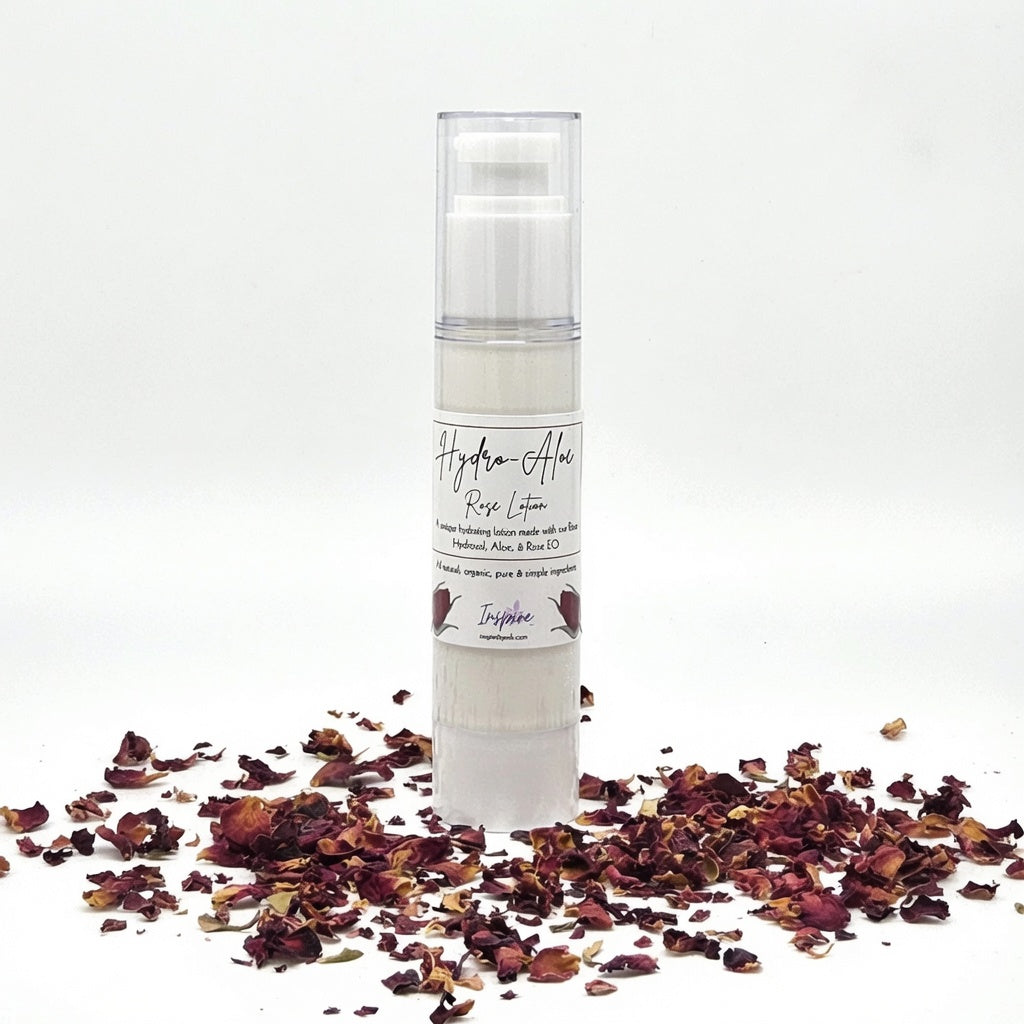 InspireByMK Hydro-Aloe Rose Lotion airless pump dispenser surrounded by dried dark red rose petals featuring all-natural hydrating lotion with rose hydrosol, aloe vera, and rose essential oil for skincare