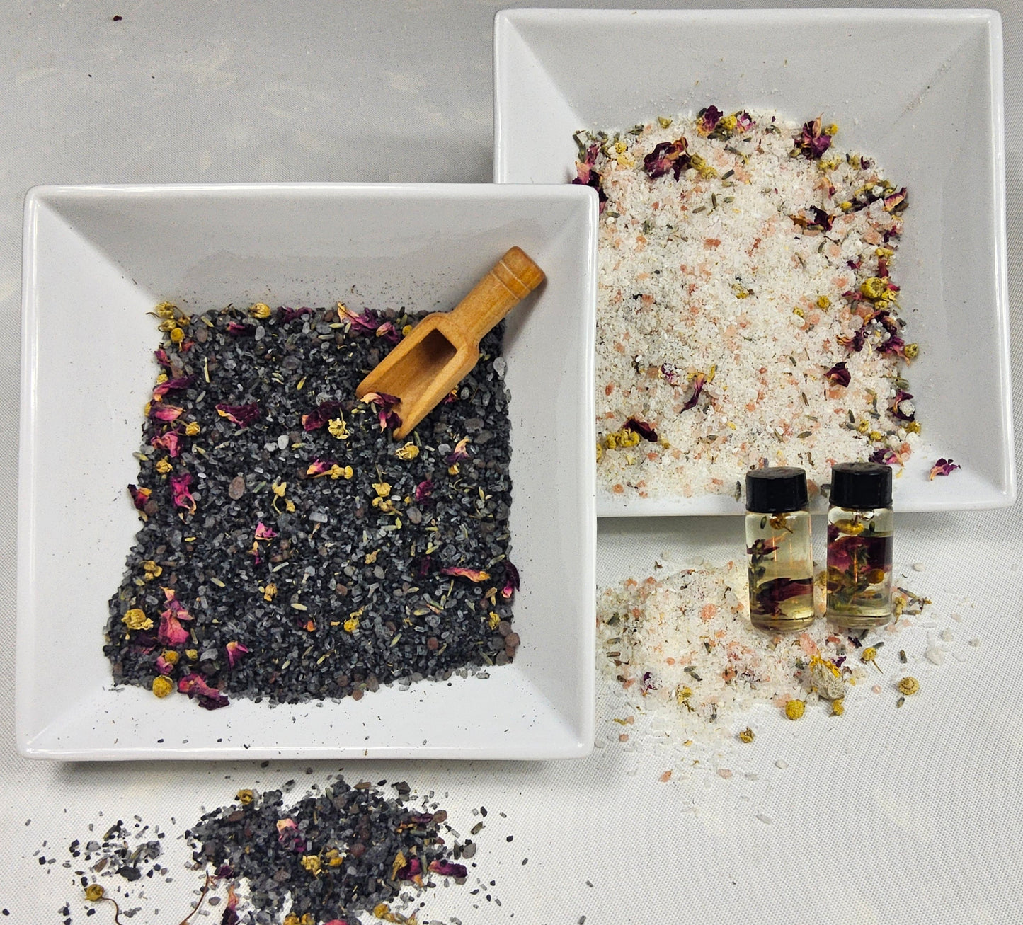 InspireByMK Floral bath salts comparison featuring dark lava blend and light epsom blend with dried rose petals, jasmine, lavender, chamomile, and goldenrod in white ceramic bowls with wooden scoop and complementary floral hydrosol bottles for natural aromatherapy spa soaks