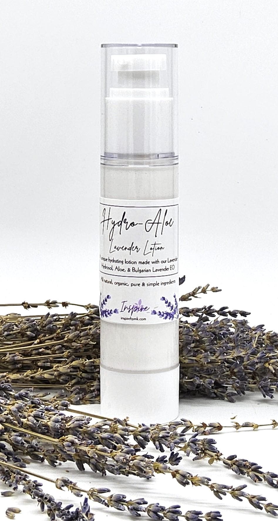 InspireByMK Hydro-Aloe Lavender Lotion airless pump bottle surrounded by dried purple lavender stems showing all-natural skincare moisturizer with lavender hydrosol, aloe vera, and Bulgarian lavender essential oil